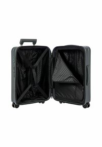 Valigia rigida grigia aperta che rivela un interno nero testurizzato con motivo esagonale, cinturini regolabili e una tasca con zip.