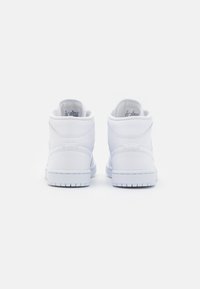 Białe sneakersy typu high-top wykonane z gładkiej skóry, z wyściełanym kołnierzem, okrągłym noskiem i gumową podeszwą z teksturowanym wzorem bieżnika.