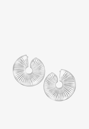 Boucles d'oreilles créoles en métal argenté avec un design en spirale, comportant des lignes découpées et une finition brillante. Chaque boucle a une forme circulaire.