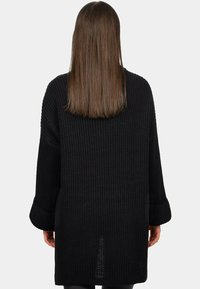 Maglione nero a vestibilità ampia con trama a costine, maniche larghe e orlo spacco sul retro. Realizzato in un morbido materiale knit spesso.