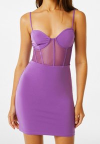 Abito viola con una silhouette aderente, parte superiore simile alla seta con pannelli in rete trasparente e sottili spalline regolabili. Texture liscia in tutto l'abito.