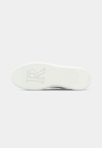 Semelle de sneaker blanche avec logo "R" texturé et marquage "REPLAY", taille indiquée comme 40 sur la zone du talon.