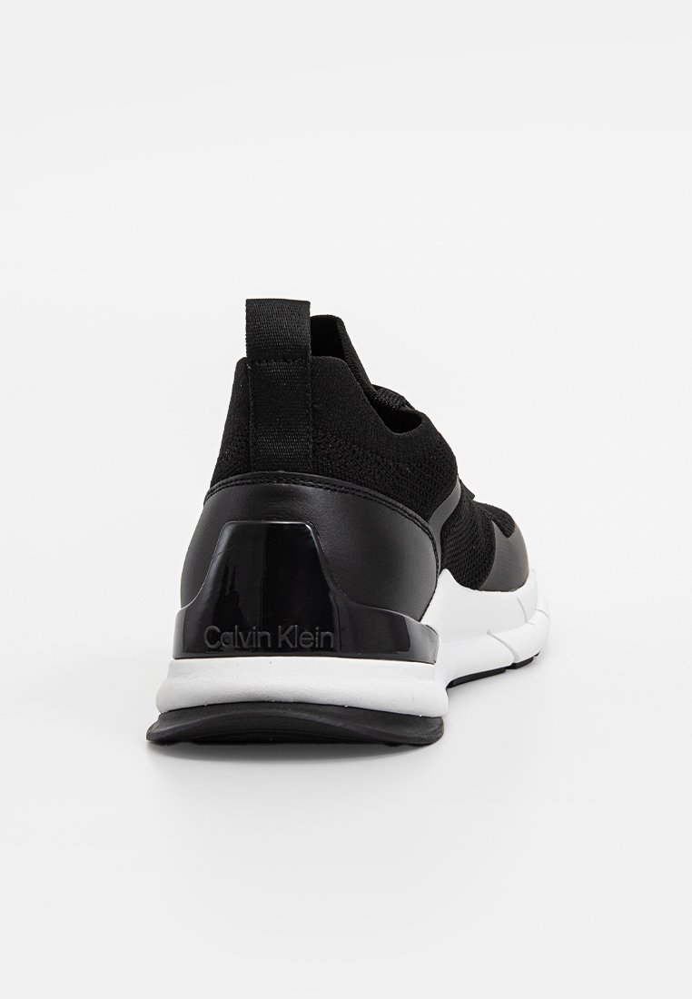 Baskets de sport noires avec un dessus en tricot, un design élégant, une semelle en caoutchouc et un détail de talon noir brillant avec le logo "Calvin Klein".