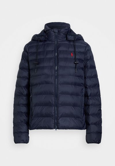 Navy puffer jacket with a zip closure, detachable hood, elastic cuffs, and red logo on the left chest. Features quilted texture and lined hood.