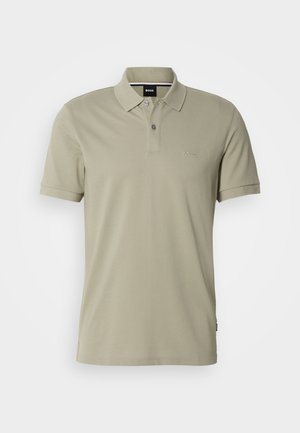 Polo shirt in light olive green, short sleeves, made from soft fabric. Features a two-button placket and subtle logo on the left chest.