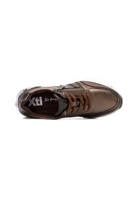 Zapatilla sintética marrón con diseño de cordones, textura suave y acentos grises. Presenta un logo en la plantilla y un detalle de cremallera en el lateral.