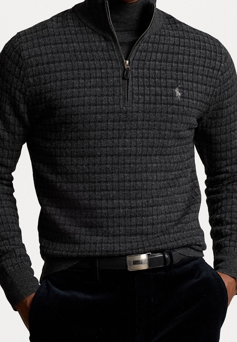 Pull gris zippé avec un motif à carreaux texturé, en mélange de laine. Il présente un col montant et un petit logo brodé sur la poitrine.