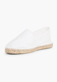 Espadrilles en toile blanche avec une semelle en corde de jute, présentant un design à enfiler et des détails cousus le long du bord supérieur.