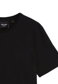 Sort kortærmet T-shirt lavet af blødt bomuldsstof. Har rund hals, oversized pasform og et diskret prægning af logoet foran.