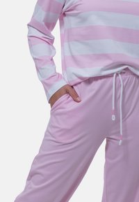Maglia a maniche lunghe a righe rosa chiaro e bianco con vestibilità comoda abbinata a pantaloni rosa a strisce con coulisse e tasche laterali.