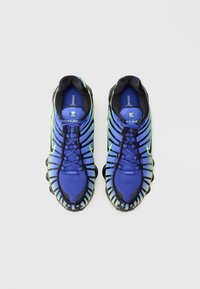 Blå og grønne løpesko med mesh-øvre, med svarte gummidetaljer, et karakteristisk såledesign og snøring.