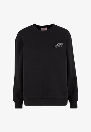 Melna kokvilnas sporta krekls ar apaļu kakla izgriezumu, garām piedurknēm un nelielu dekoratīvu logo no čiekursakmeņiem uz kreisā krūts.