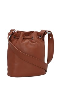Braune Leder-Eimerhandtasche mit einem Zugverschluss, Hardware in Silberoptik und einem langen, verstellbaren Riemen. Glatte Textur und runde Form.