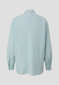 Camicia in lino blu chiaro con vestibilità rilassata, maniche lunghe, polsini con bottoni e cucitura sulla spalla posteriore. Texture liscia, design essenziale.