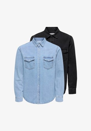 Twee denim overhemden met lange mouwen, kraag en borstzakken, een lichtblauw vooraan en een zwarte erachter op een witte achtergrond.