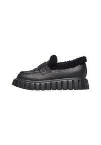 Scarpa nera in pelle senza lacci con finitura texturizzata, fodera in fleece e suola in gomma spessa e scanalata. Presenta un dettaglio della cinghia cucita.
