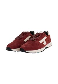 Sneaker in suede rosso con accenti bianchi, pannelli testurizzati, foderatura nera e lacci pattern. Presenta una suola curva e un dettaglio del logo sul lato.