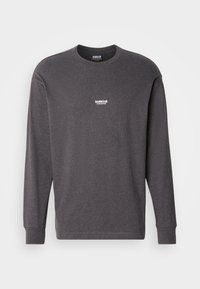 Tricou gri cu mânecă lungă, fabricat din bumbac. Are un guler rotund și un logo alb "Barbour International" pe piept. Croiu drept.