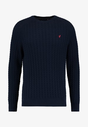 Marineblauer Strickpullover mit Zopfstrickmuster, Rundhalsausschnitt und gerippten Bündchen und Saum. Besondere Merkmale sind ein kleines rotes Logoemblem auf der Brust.