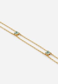 Bracciale a catena dorata con tre pietre rettangolari in turchese incastonate inquadrati dorati, con un delicato design di catena intrecciata.