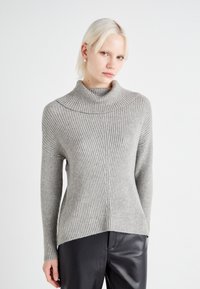 Pull en col roulé côtelé gris clair avec un large col et un ourlet arrière légèrement plus long. Fabriqué en matériau doux et texturé.