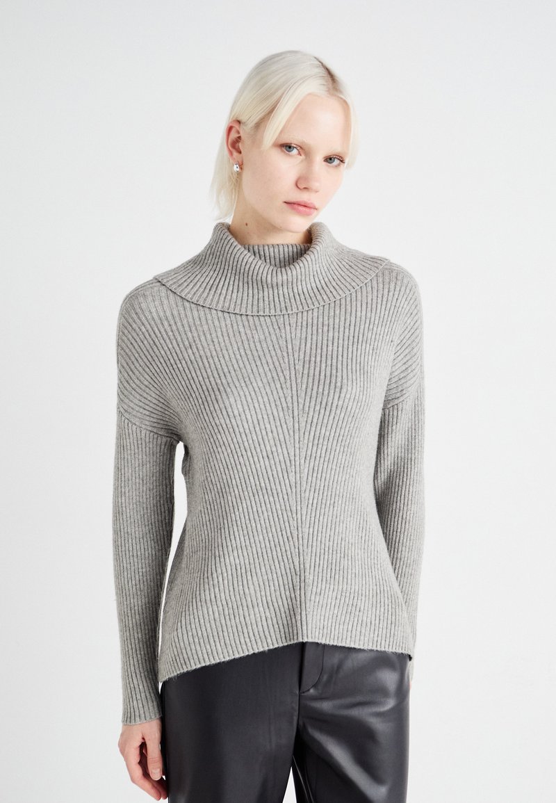 Pull en col roulé côtelé gris clair avec un large col et un ourlet arrière légèrement plus long. Fabriqué en matériau doux et texturé.