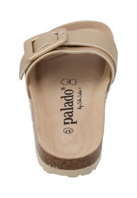 Sandale à glisser beige avec une large sangle et une boucle rectangulaire. Semelle en liège avec une surface texturée et une semelle légèrement surélevée de couleur claire.