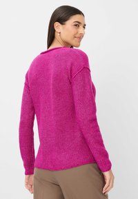 Fuchsia gestrickter Pullover mit langen Ärmeln und rundem Halsausschnitt. Gibt es mit einem strukturierten Muster und Rippdetails an den Bündchen und dem Saum.
