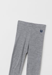 Harmaat legginssit, jotka on valmistettu pehmeästä ja joustavasta kankaasta. Niissä on vyötärönauha ja pieni tummansininen logo-tagi vasemmalla puolella.