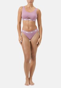 Ljuslila sportbh med ett utskuret mönster och breda axelband, matchad med bikiniunderdelar som har en logoband i midjan.