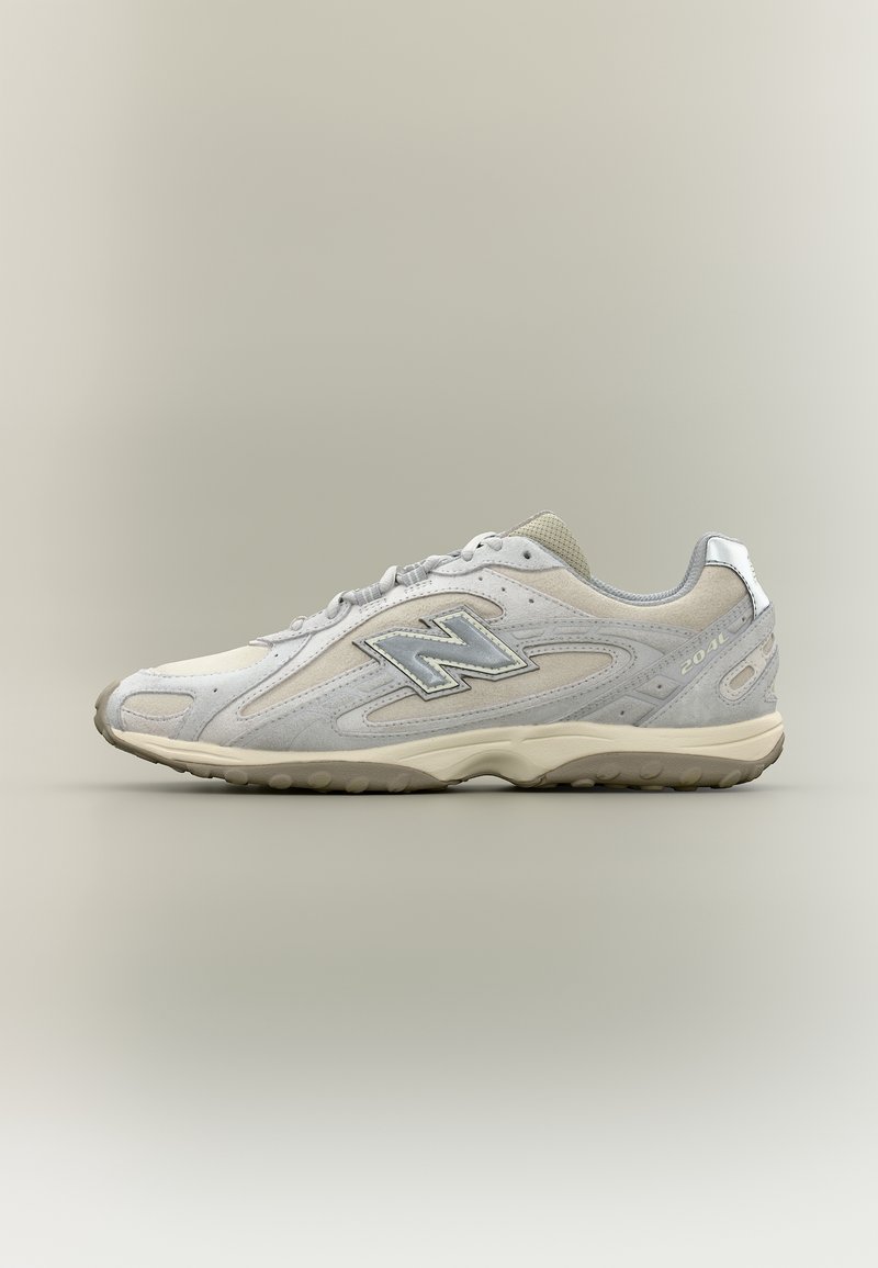 Baskets New Balance 2040 gris clair avec dessus en daim et mesh, accents réfléchissants et semelle beige sur fond neutre.