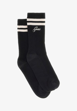 Calzini neri a coste con strisce bianche sulla parte superiore. Presentano il logo "Guess" ricamato in bianco. Realizzati in un tessuto morbido, ideali per un abbigliamento casual.