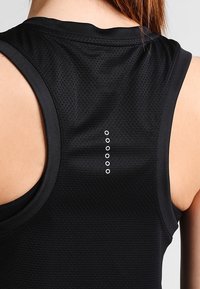 Canotta atletica nera con motivo testurizzato, design senza maniche e fila verticale di piccoli occhielli argentati sul retro del collo.