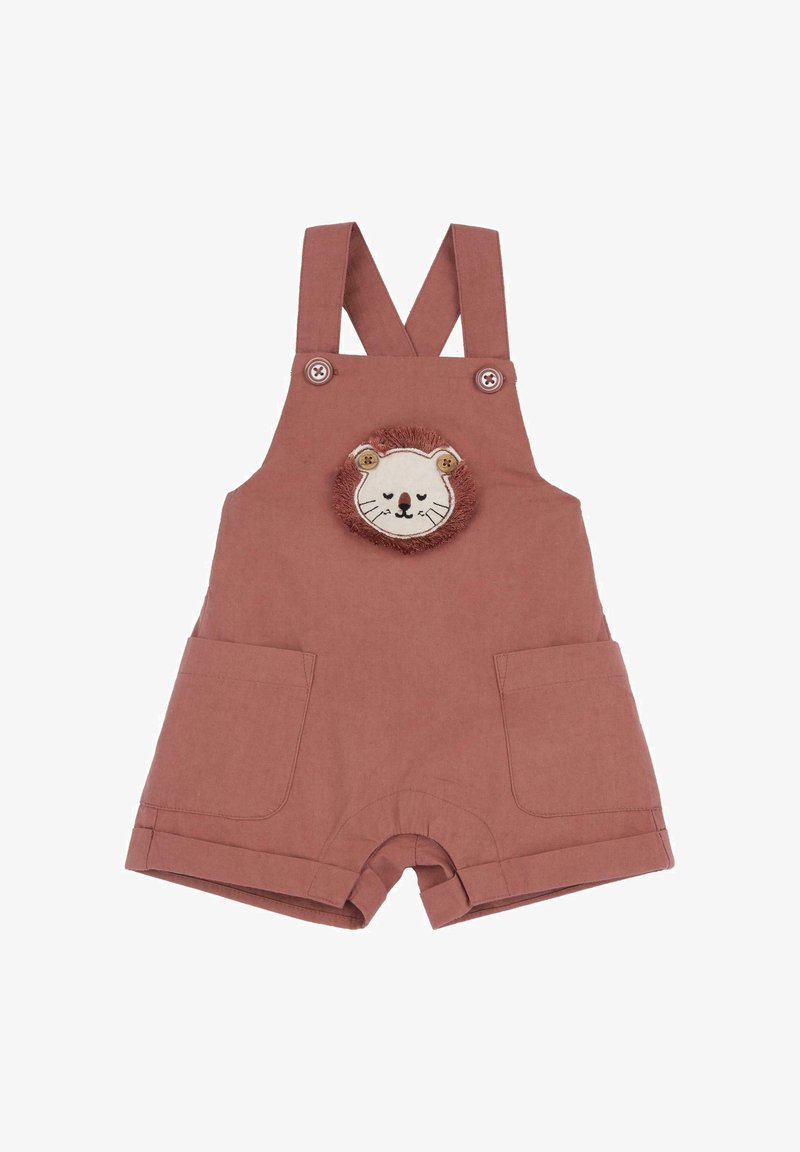 Salopette courte rose avec un patch doux représentant un visage de lion, deux poches avant et des bretelles réglables fixées par des boutons.