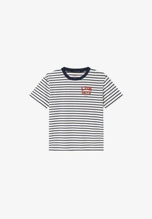 Pasiata koszulka w granatowo-białe paski, z okrągłym dekoltem. Ma na lewej piersi haftowany napis "LDN 1973" w kolorze czerwonym.