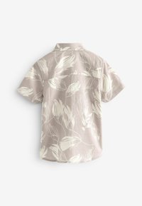 Camicia a maniche corte in morbido tessuto beige con un motivo floreale bianco, dotata di colletto a punta e orlo dritto.