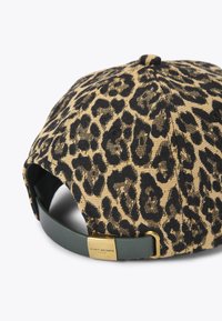 Pet met luipaardprint van geweven stof, voorzien van een bruin-zwart patroon, een groene leren band en gouden beslag met merklogo.
