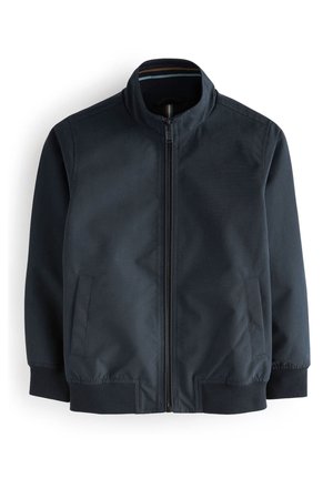 Veste zippée bleu marine avec col montant, poignets élastiques, taille élastique et deux poches fendues latérales sur fond blanc.