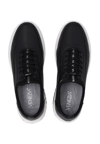 Black mesh sneakers with black laces, white accents, and textured soles. Branding visible on insoles. Modern athletic design.