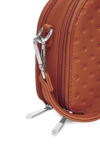 Hnědá kožená taška s tečkovanou texturou, vybavená stříbrnými prvky, dvojitými zipy a plochými stříbrnými nožičkami pro stabilitu.