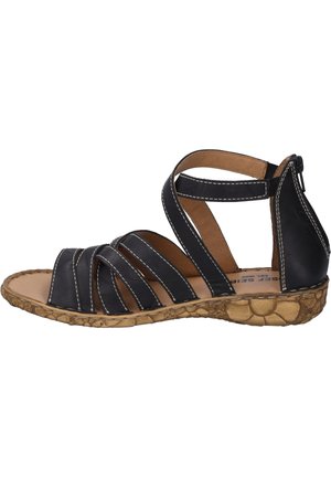 Black leather sandal with multiple crisscross straps, tan interior, and textured rubber sole, featuring white stitching and a zip back.