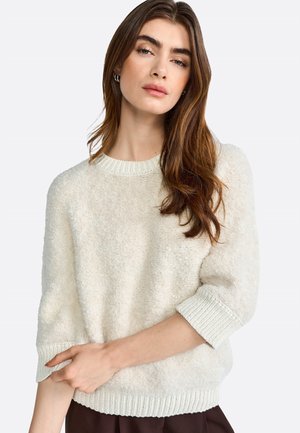 Maglione fuzzy color crema con scollo rotondo e polsini a coste, caratterizzato da una texture morbida e una vestibilità rilassata.