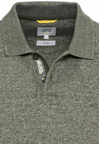 Olijfgroene polo-shirt gemaakt van gestructureerde stof, met een kraag, een drie-knopen sluiting en logo-detail aan de zijkant.