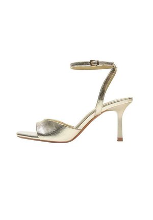 Zlatá metalická sandála na vysokom opätku s remienkom okolo členka, otvorenou špičkou a štíhlym opätkom vysokým 7 cm na bielom pozadí.