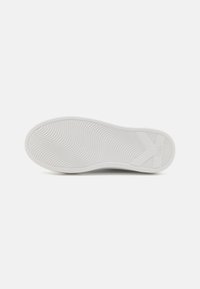 Semelle de chaussure blanche avec un motif en vagues texturé, présentant un design en forme de "X" distinctif et un détail de marque sur le côté.