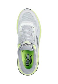 Zapatilla de malla gris con acentos en verde neón, diseño con cordones, plantilla acolchada y puntera redonda. Suela exterior de goma negra para mayor tracción.