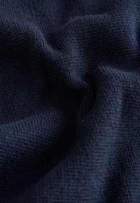 Tumesinine tekstureeritud kangas, millel on pehme, kootud muster, veidi reljeefne pind ja sile langevus.