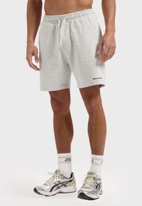 Grijze katoenen shorts met een elastische tailleband en trekkoord. Voorzien van zijzakken en zwarte logo-tekst op de zoom.