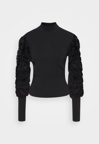 Musta neulepusero, jossa korkea pääntie. Vartalonmyötäinen malli ja pitkät hihat, vasemmassa hihassa teksturoitua, röyhelöityä pitsiä.