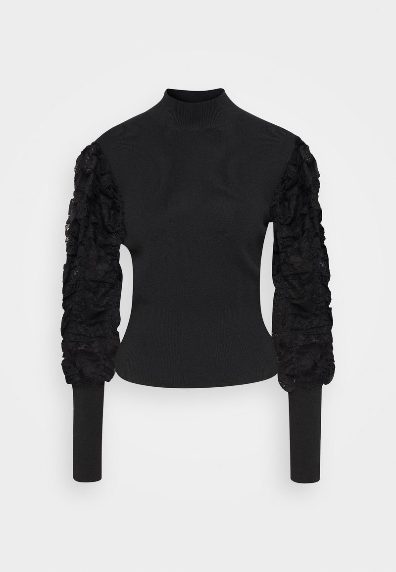Musta neulepusero, jossa korkea pääntie. Vartalonmyötäinen malli ja pitkät hihat, vasemmassa hihassa teksturoitua, röyhelöityä pitsiä.